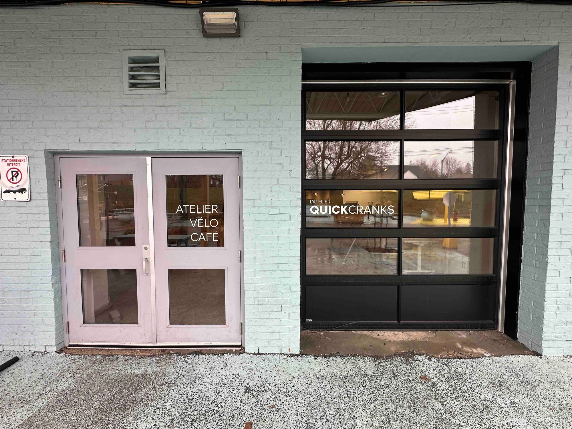Two sets of glass doors on a building with 'Atelier Velo Cafe' and 'Quick Cranks' signs.